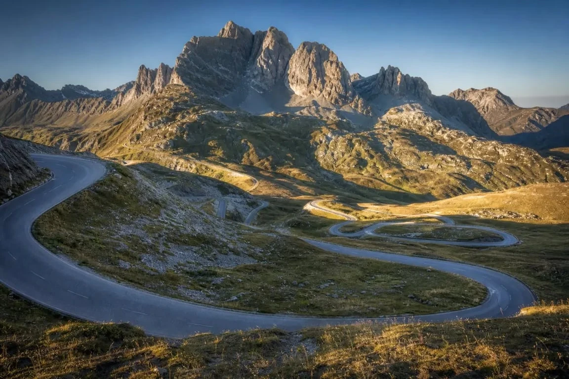 Route des Grandes Alpes : route sinueuse à travers un col alpin avec panoramas de montagne