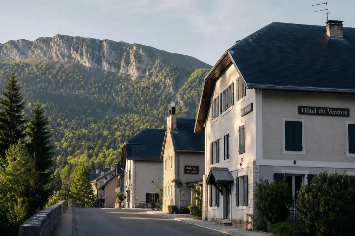 Hôtels à Lans-en-Vercors dans un village de montagne du Vercors, avec façades d’hôtels et reliefs alpins en arrière-plan